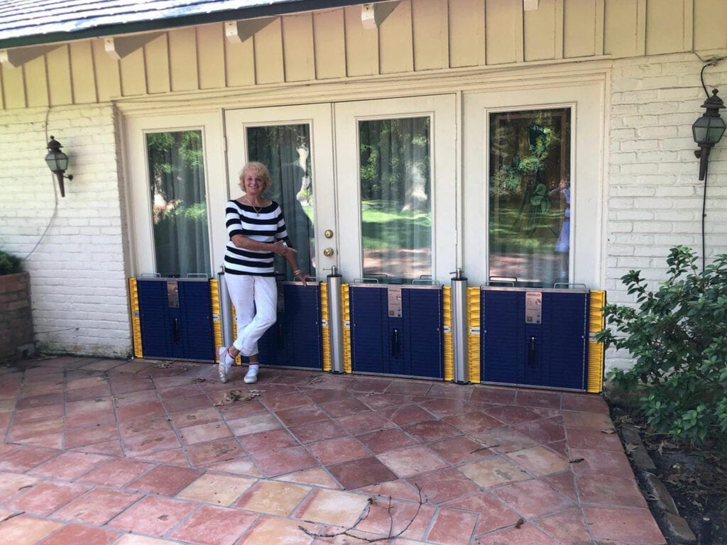 Lady Standing By DAM EASY Flood Gates In Front Of Home